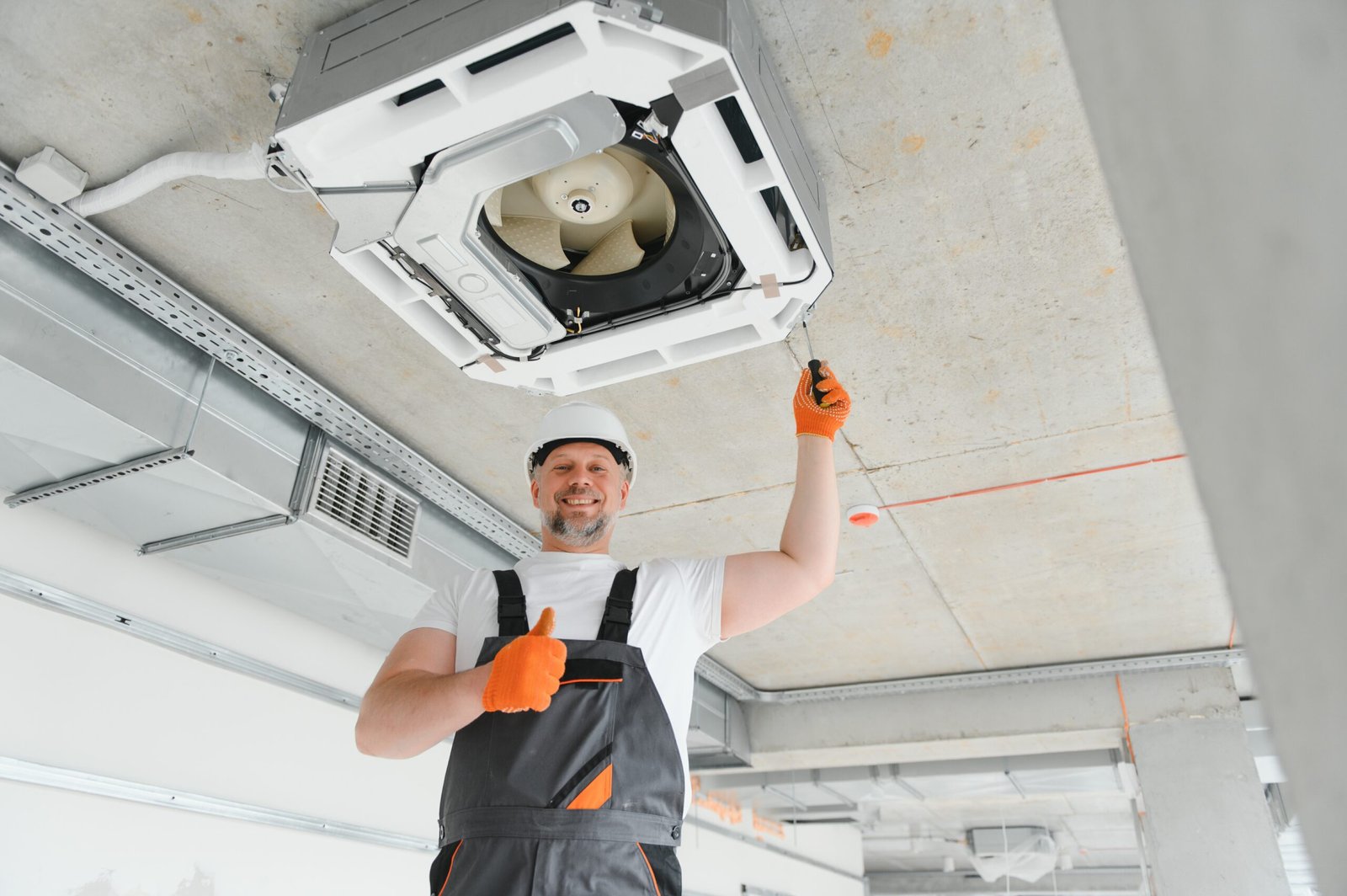 worker repairing ceiling air conditioning unit