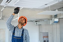 professional technician maintaining modern air conditioner indoors. space for text