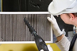 a person cleaning a dirty air filter