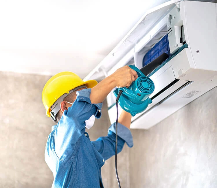 An expert technician cleaning AC coils